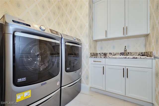 3309 SW 2nd Ln, Cape Coral, FL 33991 - laundry area with wallpapered walls, washing machine and clothes dryer, cabinet space, and light marble finish floors
