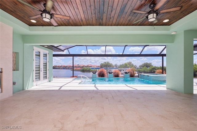 3309 SW 2nd Ln, Cape Coral, FL 33991 - view of pool featuring ceiling fan, a water view, a patio area, and a pool with connected hot tub