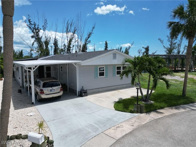 17921 Stevens Blvd, Fort Myers Beach, FL 33931 - view of front of house with concrete driveway, a carport, and a shingled roof