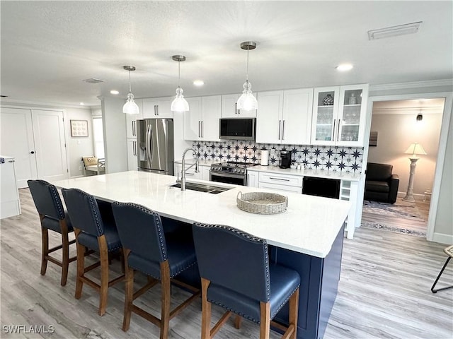 17921 Stevens Blvd, Fort Myers Beach, FL 33931 - kitchen with appliances with stainless steel finishes, a kitchen breakfast bar, white cabinets, an island with sink, and recessed lighting