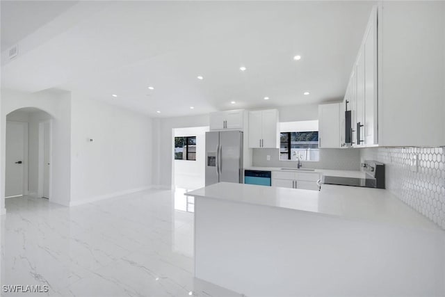 2118 Aldridge Ave, Fort Myers, FL 33907 - kitchen featuring stainless steel fridge with ice dispenser, stove, decorative backsplash, arched walkways, and recessed lighting