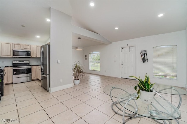 3430 35th Ave NE, Naples, FL 34120 - kitchen with stainless steel appliances, lofted ceiling, light tile patterned flooring, light brown cabinetry, and recessed lighting