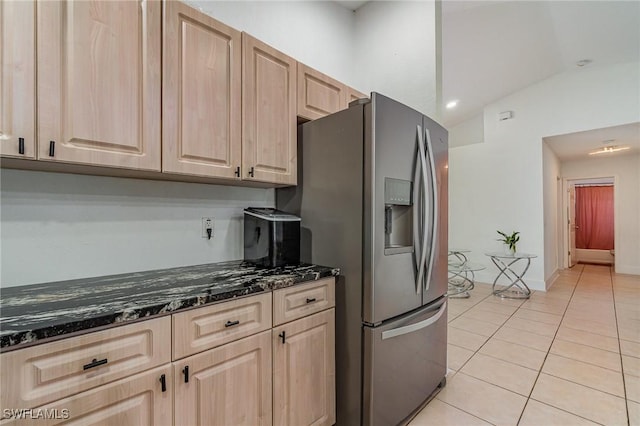 3430 35th Ave NE, Naples, FL 34120 - kitchen featuring stainless steel fridge, light brown cabinets, light tile patterned flooring, dark stone countertops, and lofted ceiling