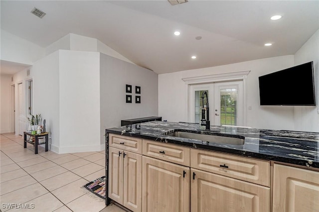 3430 35th Ave NE, Naples, FL 34120 - kitchen featuring light brown cabinetry, lofted ceiling, french doors, dark stone countertops, and light tile patterned flooring