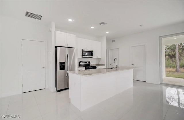 2109 Jefferson Ave, Alva, FL 33920 - kitchen with appliances with stainless steel finishes, white cabinets, recessed lighting, light tile patterned floors, and a kitchen island with sink