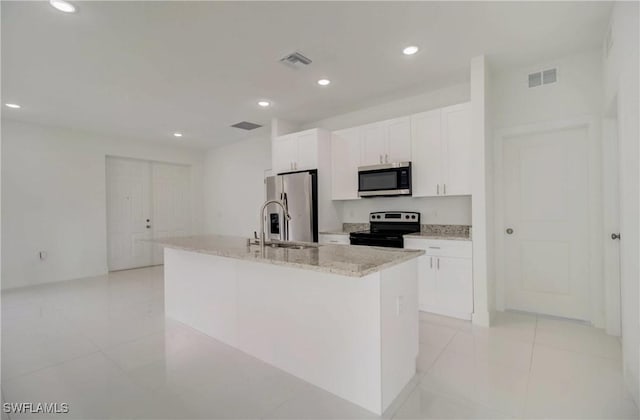 2109 Jefferson Ave, Alva, FL 33920 - kitchen featuring stainless steel appliances, white cabinetry, recessed lighting, an island with sink, and light tile patterned floors
