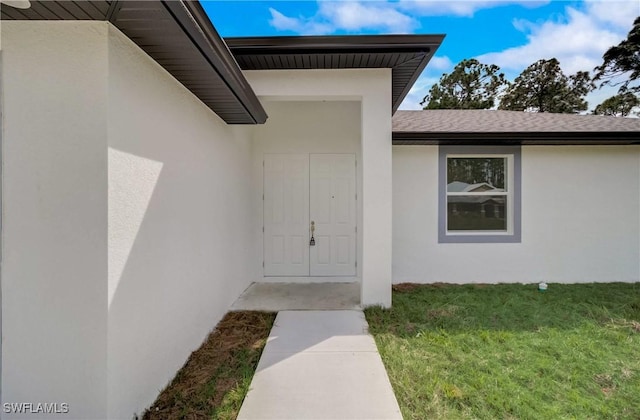 2109 Jefferson Ave, Alva, FL 33920 - entrance to property with stucco siding, a shingled roof, and a lawn