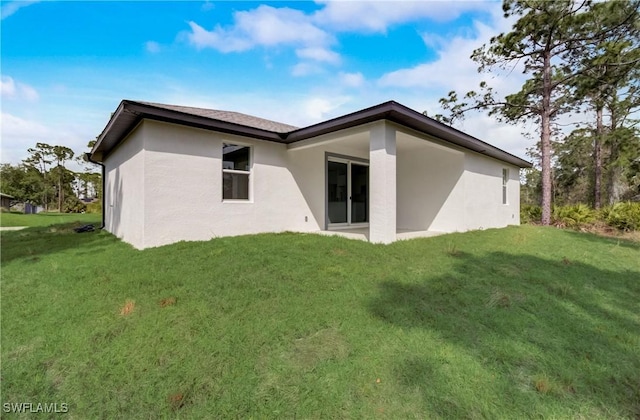 2109 Jefferson Ave, Alva, FL 33920 - back of house with stucco siding and a lawn