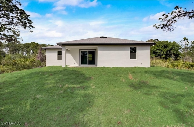 2109 Jefferson Ave, Alva, FL 33920 - back of house with stucco siding and a lawn
