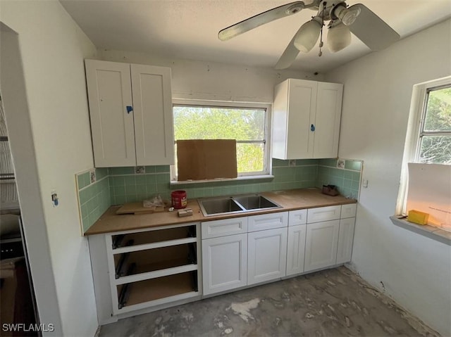 1262 Joerin Ave, North Fort Myers, FL 33903 - kitchen featuring white cabinetry, concrete floors, decorative backsplash, and ceiling fan