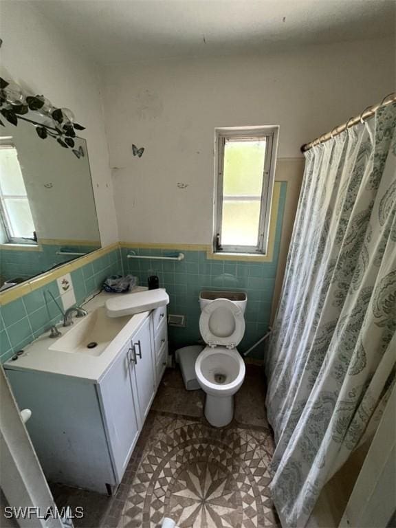 1262 Joerin Ave, North Fort Myers, FL 33903 - full bathroom with vanity, a wainscoted wall, and tile walls
