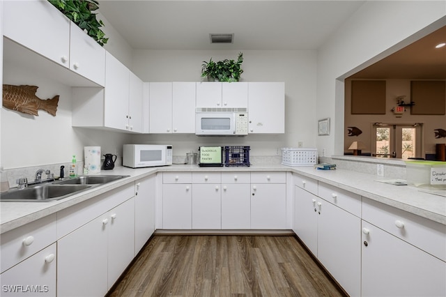 15041 Lakeside View Dr Unit 2104, Fort Myers, FL 33919 - kitchen with white microwave, light countertops, dark wood finished floors, and white cabinets