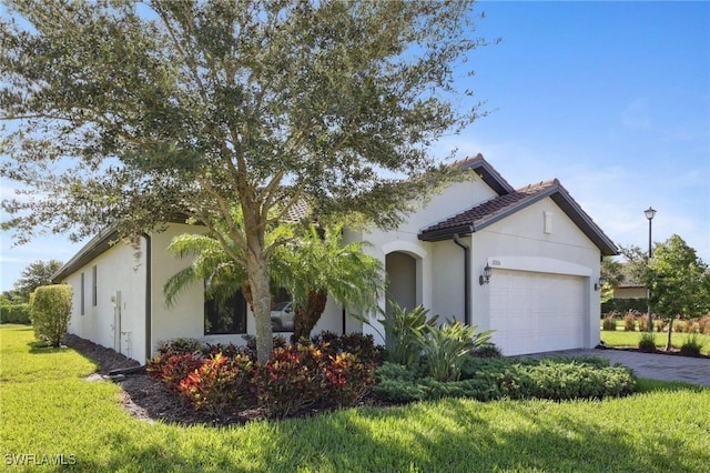 17215 Hadlow Pl, Fort Myers, FL 33967 - view of front of house featuring asphalt driveway, an attached garage, stucco siding, and a front lawn