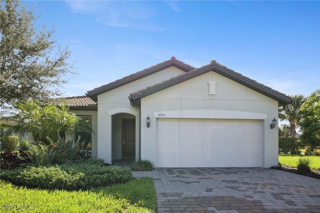 17215 Hadlow Pl, Fort Myers, FL 33967 - view of front of house with stucco siding, driveway, a garage, and a tiled roof