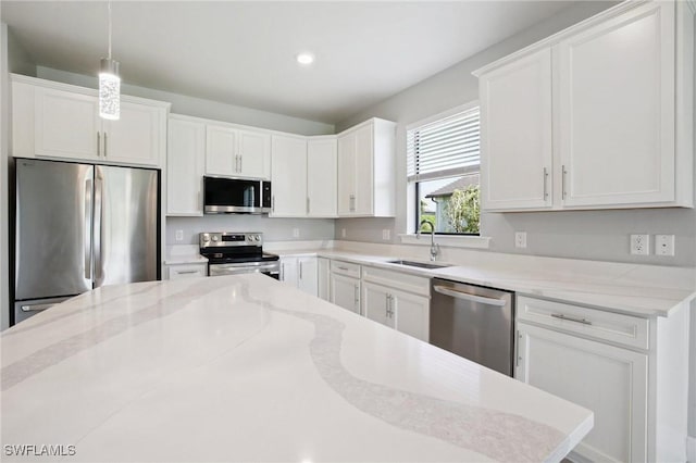 17215 Hadlow Pl, Fort Myers, FL 33967 - kitchen featuring appliances with stainless steel finishes, white cabinetry, hanging light fixtures, light stone countertops, and recessed lighting