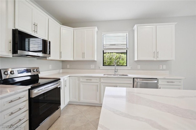 17215 Hadlow Pl, Fort Myers, FL 33967 - kitchen featuring appliances with stainless steel finishes, white cabinetry, light tile patterned floors, and light stone countertops