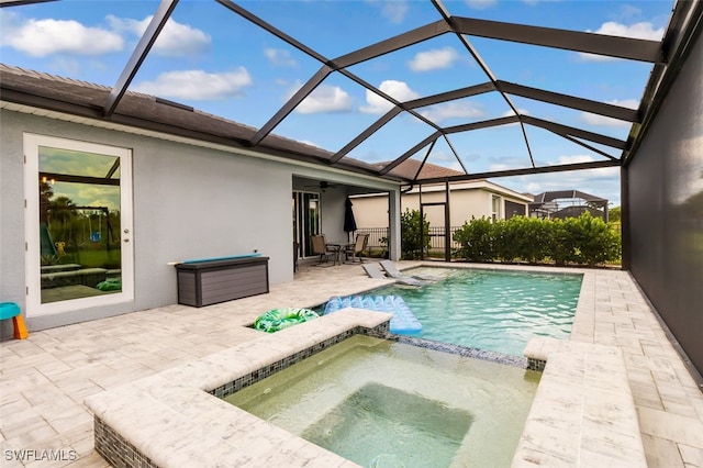 9760 Mirada Blvd, Fort Myers, FL 33908 - view of swimming pool with a patio area, a ceiling fan, a pool with connected hot tub, and glass enclosure