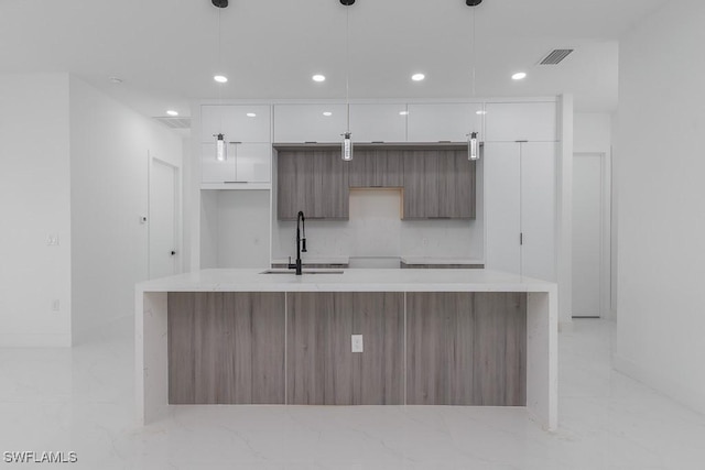 3209 22nd St SW, Lehigh Acres, FL 33976 - kitchen featuring modern cabinets, white cabinets, light marble finish flooring, a large island with sink, and recessed lighting