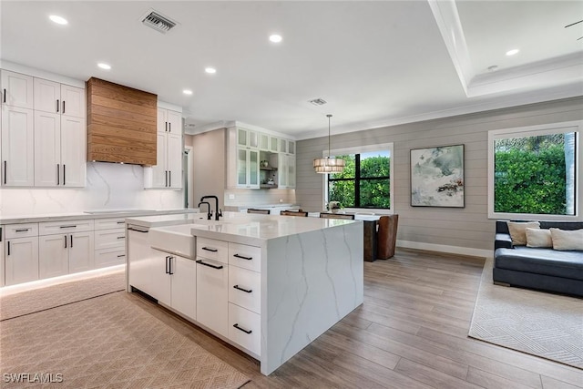 234 Legacy Ct, Naples, FL 34110 - kitchen featuring ornamental molding, an island with sink, white cabinetry, light wood-style flooring, and recessed lighting