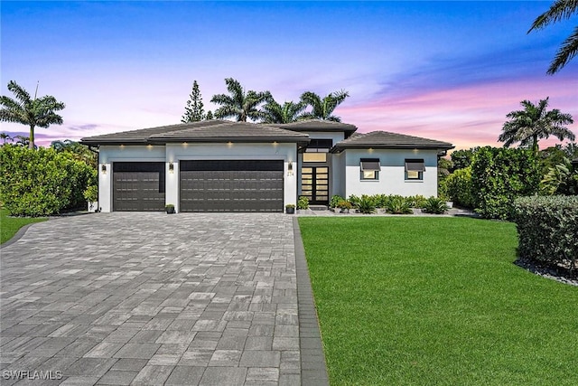 234 Legacy Ct, Naples, FL 34110 - prairie-style house featuring decorative driveway, a garage, a lawn, and stucco siding