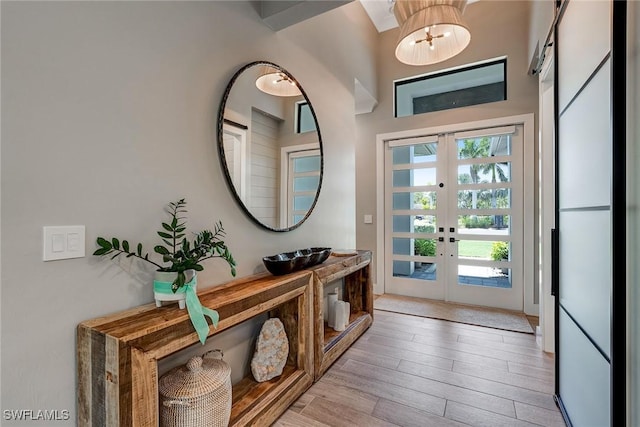 234 Legacy Ct, Naples, FL 34110 - doorway with french doors, wood finished floors, and a chandelier