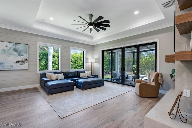 234 Legacy Ct, Naples, FL 34110 - living room with a tray ceiling, plenty of natural light, french doors, wood finished floors, and crown molding