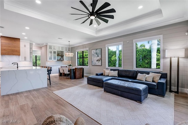 234 Legacy Ct, Naples, FL 34110 - living room featuring a raised ceiling, ceiling fan, recessed lighting, crown molding, and light wood-style floors