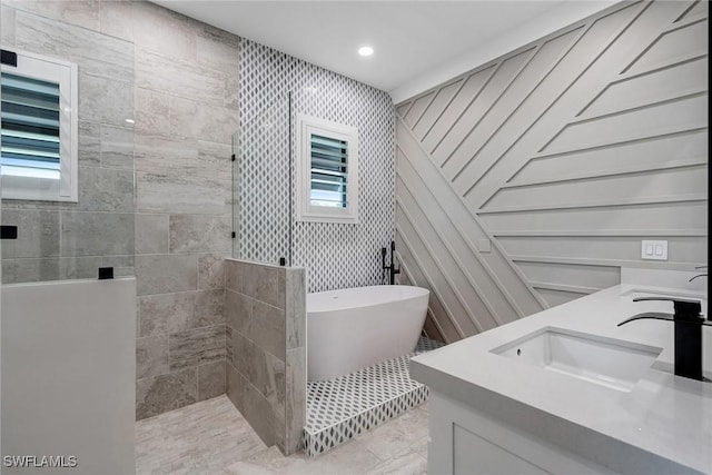 234 Legacy Ct, Naples, FL 34110 - bathroom with walk in shower, a freestanding bath, double vanity, and recessed lighting