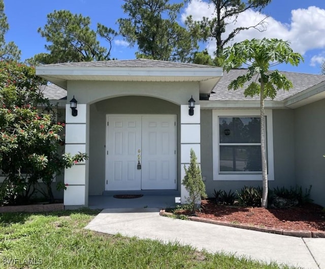 200 W 17th St, Lehigh Acres, FL 33972 - property entrance featuring a shingled roof and stucco siding