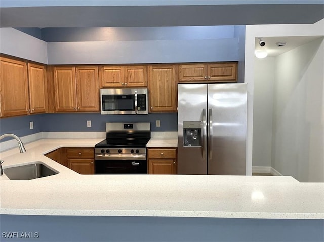 200 W 17th St, Lehigh Acres, FL 33972 - kitchen with stainless steel appliances, brown cabinetry, and light stone counters