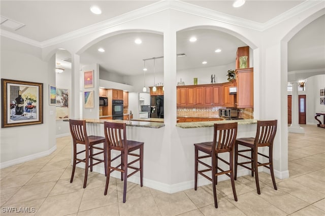 5251 Westminster Dr, Fort Myers, FL 33919 - kitchen with black appliances, brown cabinets, backsplash, light tile patterned floors, and light stone counters