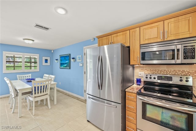 5251 Westminster Dr, Fort Myers, FL 33919 - kitchen featuring appliances with stainless steel finishes, backsplash, light tile patterned floors, and light countertops