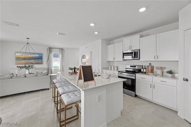 17251 Monte Isola Way N, Fort Myers, FL 33917 - kitchen with stainless steel appliances, white cabinets, light countertops, open floor plan, and recessed lighting