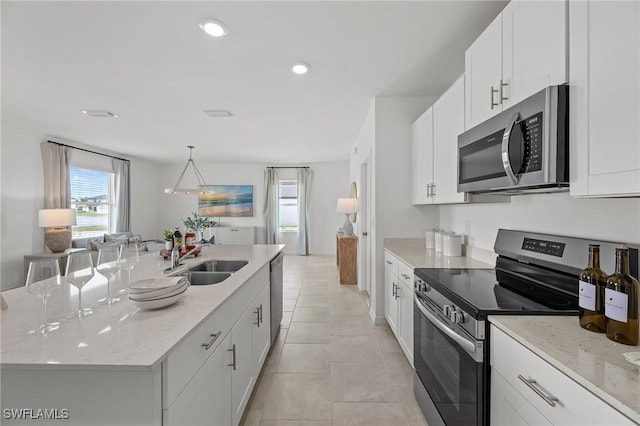 17251 Monte Isola Way N, Fort Myers, FL 33917 - kitchen featuring appliances with stainless steel finishes, plenty of natural light, white cabinetry, a kitchen island with sink, and recessed lighting