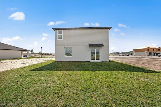 17251 Monte Isola Way N, Fort Myers, FL 33917 - rear view of house featuring a yard and stucco siding