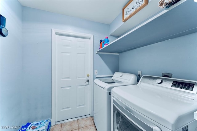 4402 Ruth Ave S, Lehigh Acres, FL 33976 - laundry area with washer and clothes dryer and light tile patterned floors