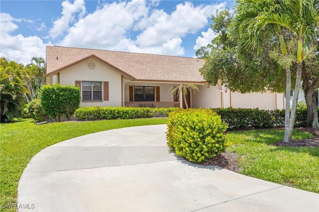 116 Sharwood Dr, Naples, FL 34110 - ranch-style home featuring a front yard, stucco siding, a porch, and roof with shingles