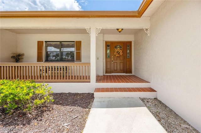 116 Sharwood Dr, Naples, FL 34110 - doorway to property featuring stucco siding and covered porch