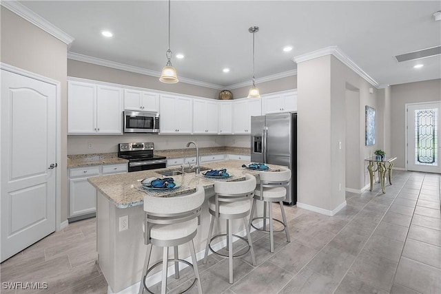 19368 Elston Way, Estero, FL 33928 - kitchen featuring appliances with stainless steel finishes, crown molding, an island with sink, a breakfast bar area, and white cabinets