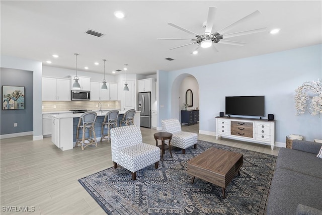 19387 Elston Way, Estero, FL 33928 - living room with arched walkways, a ceiling fan, recessed lighting, and light wood-type flooring