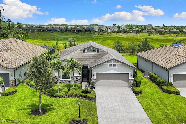 19387 Elston Way, Estero, FL 33928 - view of front of home featuring stone siding, a residential view, driveway, a front lawn, and a garage