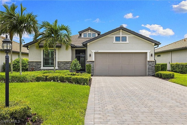19387 Elston Way, Estero, FL 33928 - craftsman inspired home with stone siding, stucco siding, a front yard, and a garage