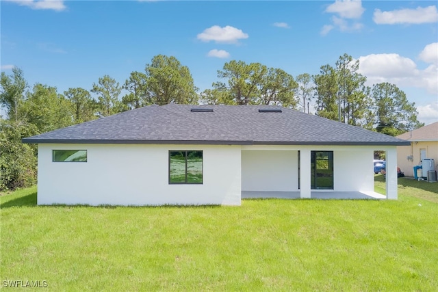 3709 6th St SW, Lehigh Acres, FL 33976 - back of house with a shingled roof, a lawn, and stucco siding