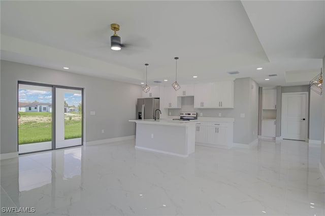 3709 6th St SW, Lehigh Acres, FL 33976 - kitchen with electric range oven, stainless steel fridge, white cabinetry, an island with sink, and a ceiling fan