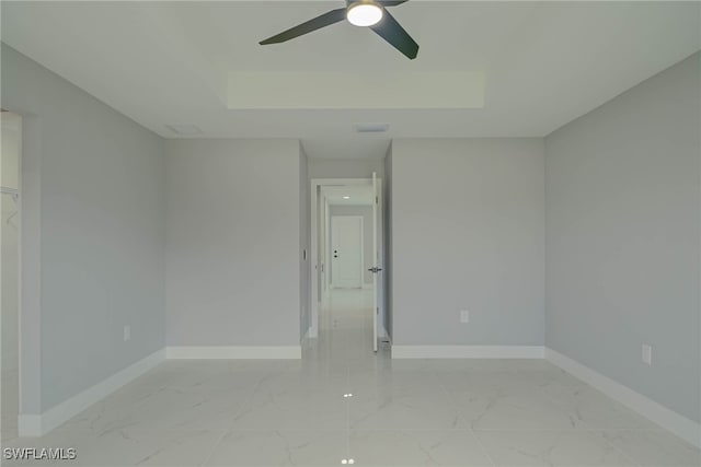 3709 6th St SW, Lehigh Acres, FL 33976 - empty room featuring marble look tile flooring, ceiling fan, and a raised ceiling