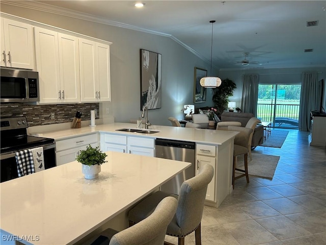 6023 Ellerston Way Unit 1825, Ave Maria, FL 34142 - kitchen featuring appliances with stainless steel finishes, a peninsula, open floor plan, a ceiling fan, and ornamental molding