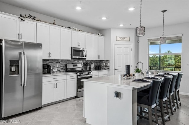 43301 Water Bird Way Unit 5221, Punta Gorda, FL 33982 - kitchen with appliances with stainless steel finishes, light tile patterned floors, an island with sink, recessed lighting, and light countertops