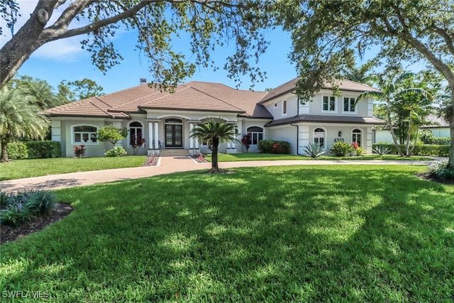 4323 Silver Fox Dr, Naples, FL 34119 - view of front of house with french doors, stucco siding, a front lawn, and a chimney