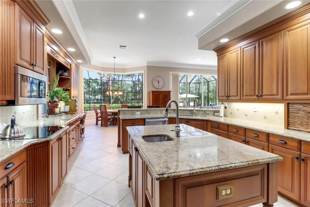 4323 Silver Fox Dr, Naples, FL 34119 - kitchen featuring stainless steel appliances, an island with sink, tasteful backsplash, brown cabinets, and crown molding