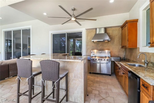 4323 Silver Fox Dr, Naples, FL 34119 - kitchen featuring wall chimney exhaust hood, a center island, a ceiling fan, brown cabinetry, and light stone countertops